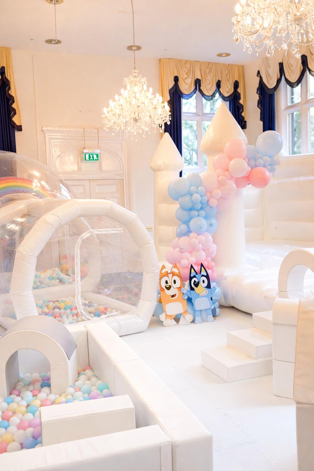 Luxury white bouncy castle and soft play in an elegant ballroom